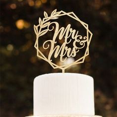 a wedding cake topper with the words mr and mrs on it in gold foil