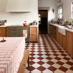 a kitchen with checkered tile flooring and wooden cabinetry, along with an oven