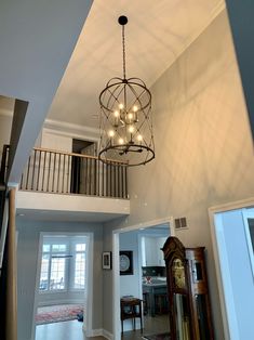 a chandelier hanging from the ceiling in a living room next to a doorway