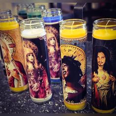 three candles are sitting on a table with the images of jesus and mary in them