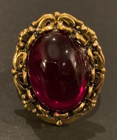 This antique gold Gothic style adjustable band ring features a beautiful 18x13mm Garnet Red or Amethyst Czech cabochon. This ring also comes in antique silver. You can choose your preferred finish as well as a Czech glass cabochon color in the drop down menu upon ordering. All Moon Grove Designs jewelry comes beautifully gift boxed and ready for giving to yourself of someone special. Luxury Polished Cabochons For Engagement, Luxury Vintage Cabochon Jewelry, Ornate Gold Cabochon Rings, Ornate Gold Rings With Cabochon, Vintage Cabochon Ruby Ring Gift, Vintage Cabochon Ruby Ring As Gift, Handmade Vintage Gold Ruby Ring, Antique Cabochon Ruby Ring Gift, Antique Cabochon Ruby Ring For Gift