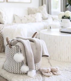 a crocheted bag sitting on top of a rug next to a white couch