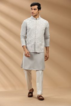 Top Details Color- Grey, Fabric - Soft Suiting Fabric With Embroidered Bottom Details Color- Off White, Fabric - Dhupion Silk, Style - Aligadi Pajama Package Include :INCLUDES 1 BANDI,1 KURTA,1 ALIGADI. Turban ,Mojari And Other Accessories Are Not Sold Along With The Dress. CARE: DRY CLEAN ONLY Additional Information : - As This Sherwani/Waistcoat/Kurta Are Made As Per Orders So It Is Strictly Not Acceptable Once Get Delivered .So Kindly Choose Body Fit Size . Also We Keep 2 Inches Extra Margin White Kurta Pajama Men With Jacket, Bandhgala With Chikankari Embroidery For Eid, Eid Bandhgala With Chikankari Embroidery And Stand Collar, Designer Nehru Jacket With Chikankari Embroidery And Stand Collar, Traditional Nehru Jacket With Stand Collar For Eid, Nehru Jacket For Puja And Eid, Semi-stitched Nehru Jacket With Cutdana, Semi-stitched Nehru Jacket With Chikankari Embroidery For Designer Wear, Unstitched Nehru Jacket With Naqshi For Eid