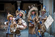 three clowns dressed in costumes and holding signs