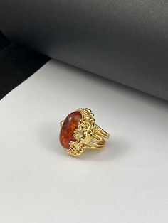 Handmade ring made entirely by hand with figures of Puttini in gilded silver Romantic style with a Baltic Amber cabochon in the center Adjustable one-piece size Dimensions Cm 3,x3,2 Inches 1.38x1.26 The item shipped will be that of the photo because it is a UNIQUE PIECE. A handmade jewel is unique and unrepeatable: it could be reproduced or proposed in other variations, but it will never be identical to another piece Produced in my workshop in the heart of Tuscany, the item is shipped from FLORE Antique Gold Signet Ring With Gemstone, 14k Gold Oval Amber Jewelry, Ornate Yellow Gold Gemstone Rings, Ornate Gold Oval Cabochon Jewelry, Gold Sterling Silver Jewelry With Cabochon, Antique Yellow Gold Oval Cabochon Ring, Sterling Silver Gold Rings With Gemstone, Gold Sterling Silver Rings With Gemstone, Collectible Gold Intaglio Jewelry