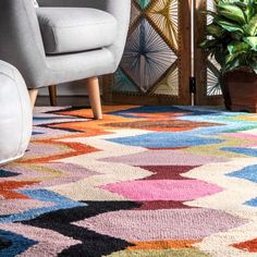 a living room with a colorful rug and chair