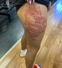 a woman with a dragon tattoo on her thigh