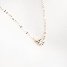 Our Solitaire Necklace is classic and sophisticated. Simple enough to wear everyday, yet elegant enough to wear out on the town! The gem has a stunning burst of glimmer when it catches the light. We love it paired with our Herringbone Necklace! DETAILS Necklace length: 16" with 2" extender 6mm cubic zirconia stone Gold filled -or- sterling silver bezel, chain, & findings Matching ring: Gold Solitaire Ring Floating Diamond Necklace, Dainty Diamond Necklace, Floating Necklace, Pearl Chain Necklace, Solitaire Necklace, Detailed Necklace, Herringbone Necklace, Gold Solitaire Ring, Necklace Bridal