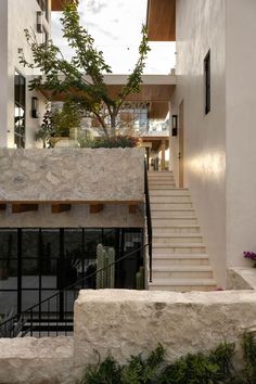 the stairs lead up to the upper level of this modern house, which has been designed with natural stone and wood