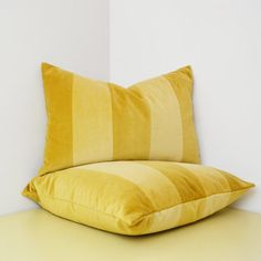 a yellow pillow sitting on top of a white table