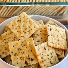 some crackers are in a white bowl on a table