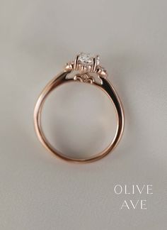 an engagement ring is shown on a white surface with the words olive ave written below it