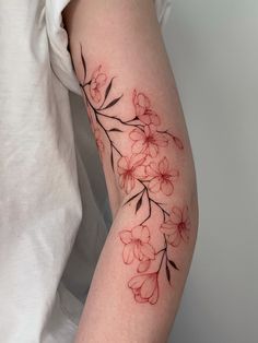 a woman's arm with red flowers on it and black outline in the middle