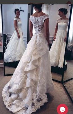 a woman in a white wedding dress looking at herself in the mirror with her reflection