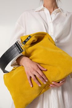 Akathi bag in yellow. A beautiful large hobo bag which is ideal for every day use. Not just a shoulder bag, a statetment tote which can easily be used as a shopper bag, even as a beach bag. It's loose minimalistic look makes it modern and unique. Handmade in our studio from lux italian suede yellow leather and a premium black cow leather for the strap. Big rectangular metal loops in silver are used to connect the strap with the bag and a silver swivel clasp is added in the interior for handling Yellow Bucket Shoulder Bag With Detachable Handle, Yellow Bucket Bag With Detachable Handle For Daily Use, Yellow Bucket Bag Tote With Detachable Handle, Yellow Bucket Bag With Detachable Handle, Chic Yellow Top Handle Bucket Bag, Yellow Bags With Leather Handles For On-the-go, Modern Yellow Shoulder Bag For On-the-go, Yellow Leather Shoulder Bag For On-the-go, Chic Yellow Pouch Bucket Bag