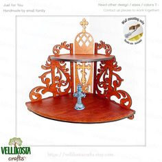 a wooden shelf with an ornate design and cross on the top, in front of a white background