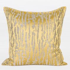 a yellow and silver pillow on a white background