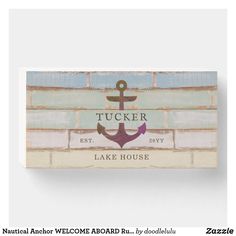 a wooden sign with an anchor on it and the words tucker lake house written in black