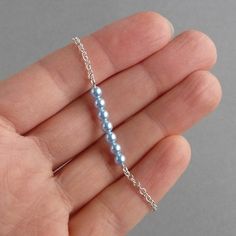 "This powder blue pearl bracelet is finished with Sterling silver chain and features a bar of light blue Swarovski pearls. These pale blue pearl bracelets make the ideal bridal party gift for bridesmaids or a \"something blue\" gift for a bride. With the exception of the 1 inch silver plated extender chain, which allow you to adjust your bracelet to fit, all of the metal elements are Sterling silver. Each minimal layering bracelet measures 7 inches / 18cm in length and is finished with a bolt ring clasp. Your pastel blue jewellery will arrive gift wrapped and ready to present as a gift or a treat to yourself. All of my items are securely packaged to ensure their safe arrival. --------------------- Matching items available --------------------- Long powder blue pearl earrings: https://www.e Baby Blue Jewelry, Blue Pearl Bracelet, Blue Pearl Earrings, Pearl Bar Necklace, Blue Wedding Jewelry, Light Blue Wedding, Jewelry King, Bleu Pastel, Etsy Bridesmaid Gifts