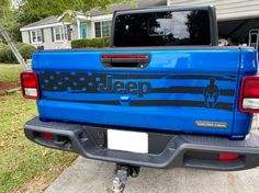 a blue truck with the word jeep painted on it's tailgate is parked in front of a house