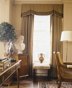 a living room filled with furniture and a window covered in curtained drapes