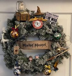 a wreath is hanging on the front door with harry potter decorations and other items around it