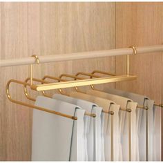 an image of clothes hanging on a rack in the closet with curtains pulled up to dry