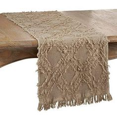 a wooden bench with a table runner on it