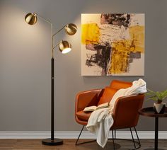 a living room with a chair, lamp and painting on the wall