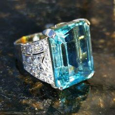 When ordering, please give us your phone number for safer Fedex shipping! RING SIZE: 58 EU 8 1/2 US PLATINUM, WHITE GOLD- Import Hallmarks 1867-1937 Austro-Hungarian Monarchy  WEIGHT: 17.20 grams  STONES: aquamarine diamonds  AQUAMARINE : 22.0 ct. 20mm x 10mm x 16mm  TOTAL DIAMOND WEIGHT: 0.46 ct.  COLOUR: I  CLARITY: Si1-Si2  CONDITION: EXCELLENT  Beautiful, stunning 1930s art deco aquamarine and diamond ring with 18k gold and platinum import hallmarks from 1867 to 1937 Austrian-Hungarian Monarchy.  It contains a total of 0.46 carats of diamonds in Si2 to Si1 clarity and color I and a huge, 22 carat icy blue aquamarine.  The ring weighs 17.20 grams, the top is 20mm long and 23mm wide.  The ring is US size 8 1/2 or EU size 58, but we offer resizing for free!  This attractive yet elegant ri Gia Certified Art Deco Octagon Ring, Art Deco Diamond Topaz Ring, Art Deco Topaz Ring With Center Stone, Formal Art Deco Topaz Ring With Emerald Cut, Art Deco Emerald Cut Topaz Ring For Formal Occasions, Formal Art Deco Emerald Cut Topaz Ring, Art Deco Topaz Ring With Diamond Center Stone, Gia Certified Art Deco Sapphire Ring For Formal Occasions, Formal Art Deco Topaz Ring With Center Stone