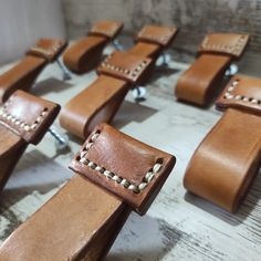 several pieces of brown leather with rivets on each side and one piece missing