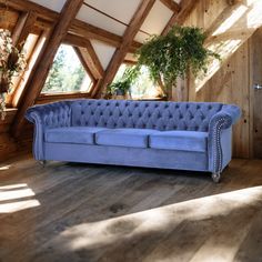 a blue couch sitting on top of a hard wood floor next to a wooden wall