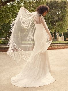 a woman in a wedding dress with a veil over her head