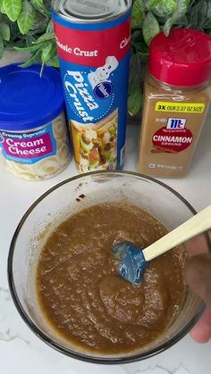 a person mixing food in a bowl with a spoon and some other ingredients around it