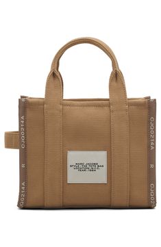 Easy top handles and an optional crossbody strap provide convenient carrying options for this lightly structured canvas tote stamped with bold branding. Top zip closure Top carry handle; removable, adjustable crossbody strap Textile Imported Chic Logo, Bold Branding, Stylish Logo, Marc Jacobs Tote, Bold Logo, Small Tote Bag, Natural Logo, Mini Tote Bag, Marc Jacobs Bag