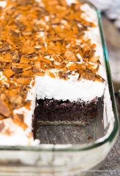 a close up of a cake in a pan with frosting and orange peels