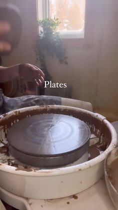 a man is working on an object in the process of being made with clay and paint