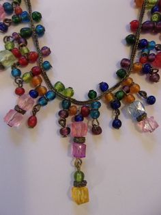 "Colorful vintage choker measures 15\" in length with a 2\" extender to adjust length. Made of square and round resin beads in shades of pink, blue, gold, green, and brown. Bronze look metal finish. Well made and in excellent condition." Cheap Multicolor Round Beads Charm Necklaces, Vintage Adjustable Multicolor Necklaces, Vintage Adjustable Necklaces With Colorful Beads, Vintage Multicolor Necklace With Adjustable Chain, Retro Multicolor Adjustable Necklaces, Vintage Multicolor Necklaces With Dangling Beads, Adjustable Multicolor Beaded Dangle Necklaces, Vintage Multicolor Handmade Choker, Adjustable Retro Jewelry With Colorful Beads