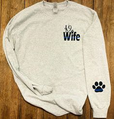 Long sleeve TShirt Front K9 Wife front.  Specify in personalization box if you want to change that too: mom, fiancé, sister, aunt...) Back has a TBL flag with K9 paw print Sleeve has a TBL paw print near cuff. to prevent any delays in your order: please specify in the personalized section what you would like on the front left chest & what you would like on the sleeve (most get a name, badge number and some add a paw) Customizable Long Sleeve T-shirt, Long Sleeve T-shirt With Name Print Gift, Police Shirt Ideas, Police Shirts Law Enforcement, Police Wife Tumbler, Police Wife Shirt, Police Shirts, Police K9, Wife Christmas