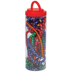 a glass jar filled with lots of colorful beads and plastic straws on top of a white background