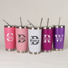 four personalized tumblers with straws in them