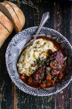 a bowl of stew with bread on the side