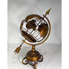 an antique brass globe with arrows on it