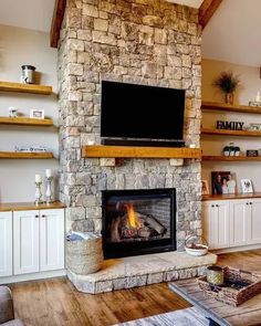 a living room with a stone fireplace and entertainment center