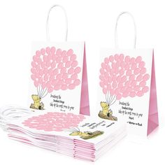 two bags with pink balloons on them are stacked next to each other and one has a card