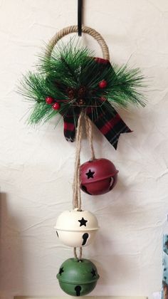 an assortment of christmas ornaments hanging from a rope on a wall next to a potted plant