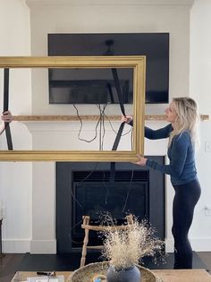 two women holding up frames in front of a fireplace with wires coming out of them