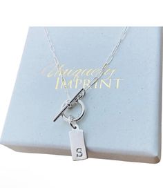 Sterling Silver Toggle Necklace                                   This is a all sterling silver toggle necklace with a tiny 14mm x 6mm personalized tag with the letter of your choice. Comes with a  18" mini paper clip chain. Please provide the following at checkout in message to seller box: -initial       Back of disc can't be stamped. To check out more personalized items from our shop please click here https://www.etsy.com/shop/UniquelyImprint Shipping/Production Times: We ship out in 1-3 busin New Bern, Toggle Necklace, Personalized Tags, Organza Bags, Name Necklace, Initial Necklace, Paper Clip, Initials, Jewelry Necklaces