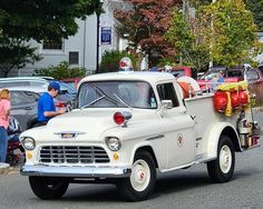 an old white truck with red bows on it's flatbed