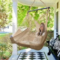 a woman sitting in a hammock on the porch